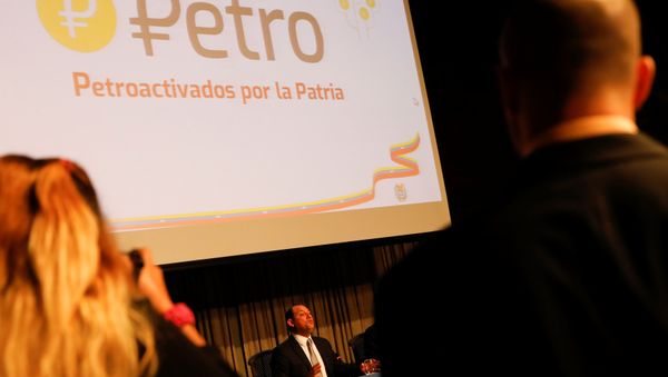 The new Venezuelan cryptocurrency the Petro logo is seen as Minister for University Education, Science and Technology Hugbel Roa talks to the media during a news conference in Caracas, Venezuela, January 31, 2018 - Sputnik International