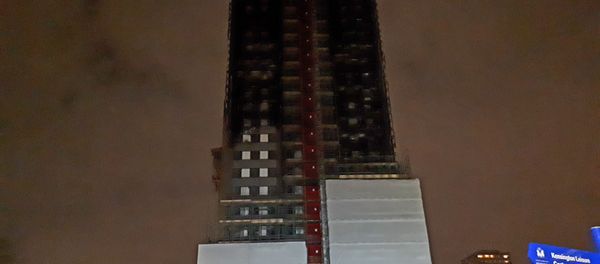 The blackened hulk of Grenfell Tower, which is only partially covered up, in north Kensington - Sputnik International