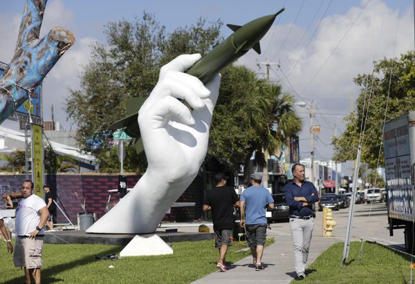 A sculpture titled Dangerous Game by Italian artist Lorenzo Quinn, right, is displayed in the Wynwood neighborhood of Miami, Friday, Dec. 8, 2017. The two-part installation shows a giant hand holding a nuclear missile as if it were a dart - Sputnik International
