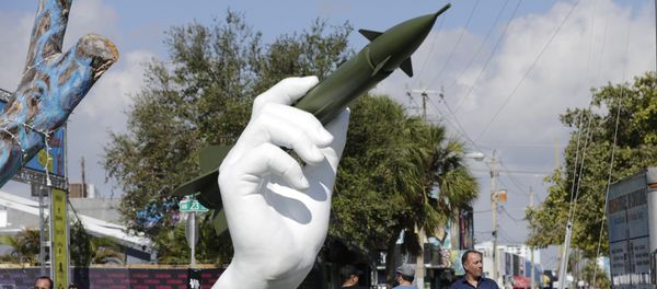A sculpture titled Dangerous Game by Italian artist Lorenzo Quinn, right, is displayed in the Wynwood neighborhood of Miami, Friday, Dec. 8, 2017. The two-part installation shows a giant hand holding a nuclear missile as if it were a dart - Sputnik International