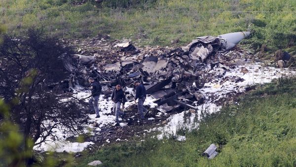 Israeli security stands around the wreckage of an F-16 that crashed in northern Israel, near kibbutz of Harduf, Saturday, Feb. 10, 2018. - Sputnik International