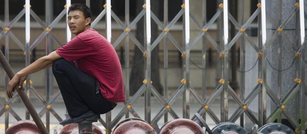 A Chinese man pause as he waits for steel pipes to be loaded onto a truck in Beijing, China. (File) - Sputnik International