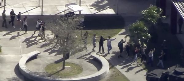 In this frame grab from video provided by WPLG-TV, students from the Marjory Stoneman Douglas High School in Parkland, Fla., evacuate the school following a shooting there on Wednesday, Feb. 14, 2018. In this frame grab from video provided by WPLG-TV, students from the Marjory Stoneman Douglas High School in Parkland, Fla., evacuate the school following a shooting there on Wednesday, Feb. 14, 2018. - Sputnik International