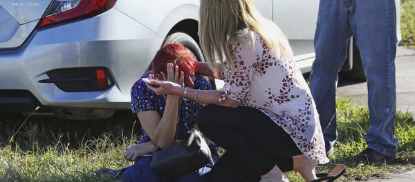 A woman consoles another as parents wait for news regarding a shooting at Marjory Stoneman Douglas High School in Parkland, Fla., Wednesday, Feb. 14, 2018. - Sputnik International