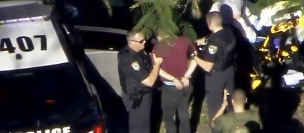 A man placed in handcuffs is led by police near Marjory Stoneman Douglas High School following a shooting incident in Parkland, Florida, U.S. February 14, 2018 in a still image from video A man placed in handcuffs is led by police near Marjory Stoneman Douglas High School following a shooting incident in Parkland, Florida, U.S. February 14, 2018 in a still image from video - Sputnik International