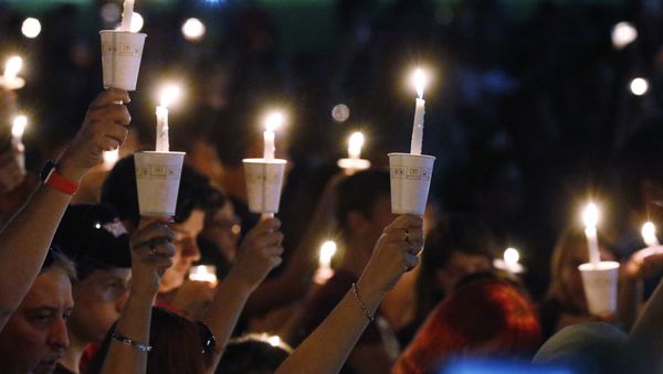 Attendees raise their candles at a candlelight vigil for the victims of the shooting at Marjory Stoneman Douglas High School, Thursday, Feb. 15, 2018, in Parkland, Fla. - Sputnik International