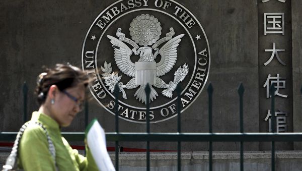A Chinese woman checks her documents as she walks past the U.S. Embassy in Beijing Friday, May 6, 2011 - Sputnik International
