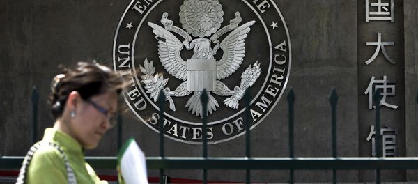 A Chinese woman checks her documents as she walks past the U.S. Embassy in Beijing Friday, May 6, 2011 - Sputnik International