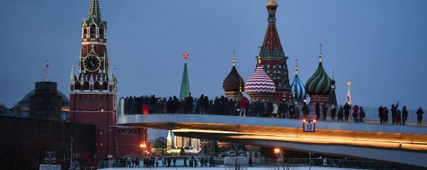 People visit Zaryadye Nature-Landscape Park in Moscow, Russia. Background from left: Spasskaya (Savior) Tower of the Moscow Kremlin and domes of Intercession of the Most Holy Theotokos on the Moat Cathedral (St. Basil's Cathedral) - Sputnik International