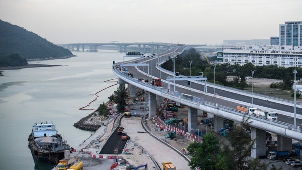 In this picture taken on November 29, 2017, a general view shows a section of the Hong Kong-Zhuhai-Macau Bridge (HKZMB) (C) that runs alongside the international airport (R) in Hong Kong - Sputnik International