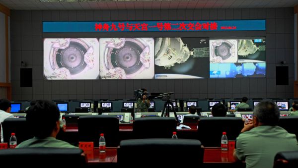 (File) Chinese technicians at the Jiuquan Space Centre monitor the Shenzhou-9 spacecraft as it prepares to link with the Tiangong-1 module just over a week into a manned space mission which includes China's first female astronaut, following an automatic docking, on June 24, 2012 - Sputnik International