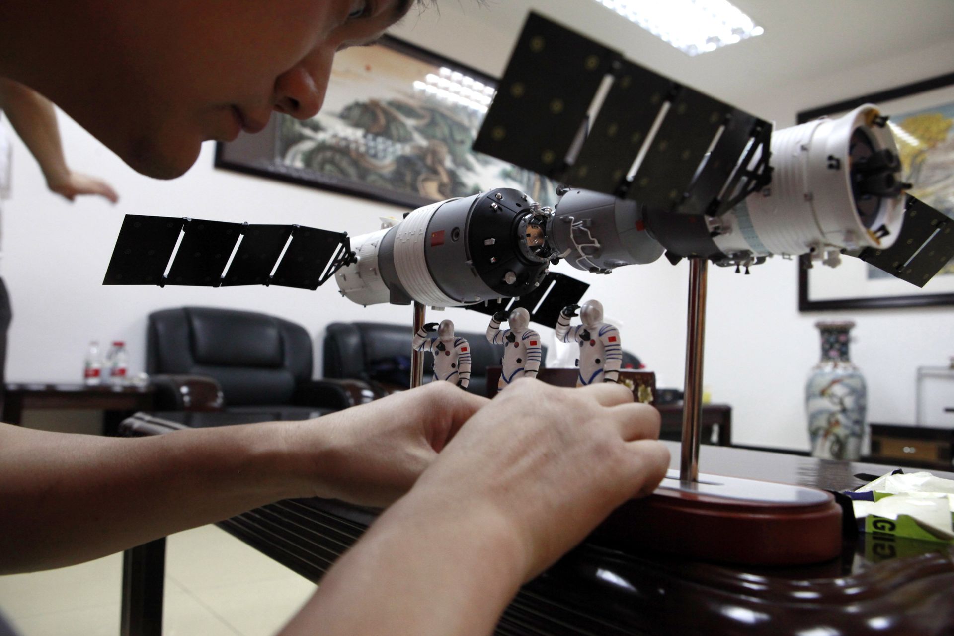 A Chinese official arranges astronaut figures with a scale model of the Shenzhou 9 module docking with China's Tiangong 1 space module to present them at a press conference at the Jiuquan satellite launch center near Jiuquan in western China's Gansu province, Friday, June 15, 2012 - Sputnik International, 1920, 29.03.2022