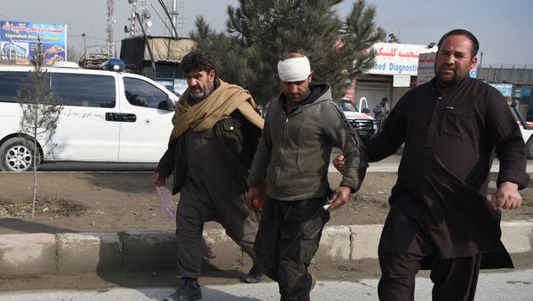 An Afghan resident assists an injured man near the site of a suicide car bomb attack targeting foreign troops in Kabul on March 2, 2018 An Afghan resident assists an injured man near the site of a suicide car bomb attack targeting foreign troops in Kabul on March 2, 2018 - Sputnik International