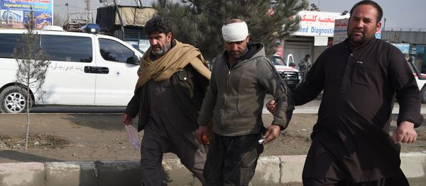 An Afghan resident assists an injured man near the site of a suicide car bomb attack targeting foreign troops in Kabul on March 2, 2018 An Afghan resident assists an injured man near the site of a suicide car bomb attack targeting foreign troops in Kabul on March 2, 2018 - Sputnik International