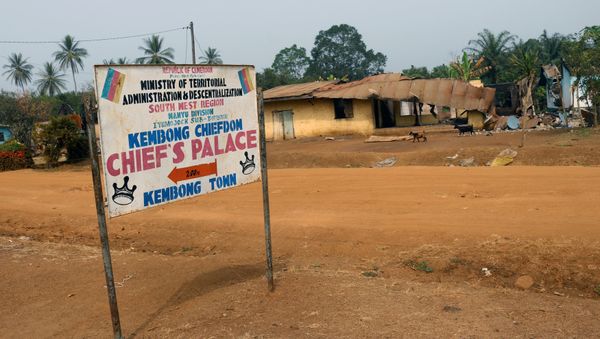 A road sign is seen in front of burned and damaged buildings in Kembong, south-west region of Cameroon December 29, 2017. Picture taken December 29, 2017 A road sign is seen in front of burned and damaged buildings in Kembong, south-west region of Cameroon December 29, 2017. Picture taken December 29, 2017 - Sputnik International