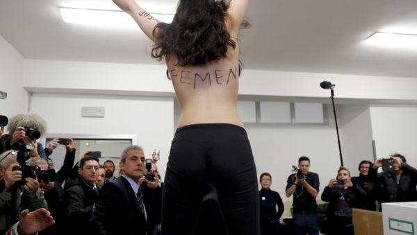 A topless Femen activist protests at a polling station where Italian former premier and leader of Forza Italia (Go Italy) party Silvio Berlusconi was about to vote, in Milan, Italy, Sunday, March 4, 2018. - Sputnik International