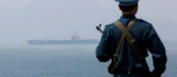 A Vietnamese soldier keeps watch in front of U.S. aircraft carrier USS Carl Vinson after its arrival at a port in Danang, Vietnam March 5, 2018 - Sputnik International