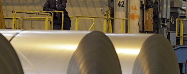 An employee looks on from behind coils of steel as acting Secretary of Labor Seth Harris speaks to workers after a tour of ArcelorMittal Steel's hot dip galvanizing line in Cuyahoga Heights, Ohio (File) - Sputnik International