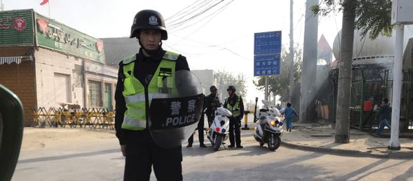 (File) In this Nov. 2, 2017 photo, a police personnel holding shield and baton guards a security post leading into a center believed to be used for re-education in Korla in western China's Xinjiang region (File) In this Nov. 2, 2017 photo, a police personnel holding shield and baton guards a security post leading into a center believed to be used for re-education in Korla in western China's Xinjiang region - Sputnik International