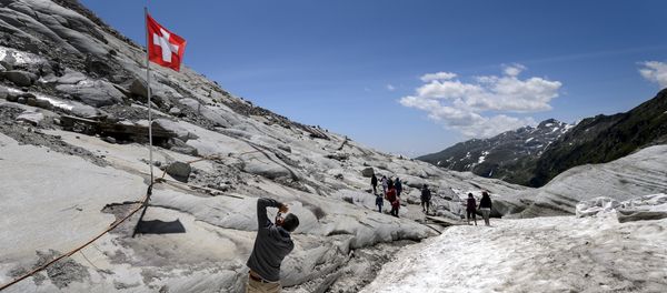 A tourist takes a picture of a Swiss flag on the Rhone Glacier covered with insulating foam to be protected from the sun on July 14, 2015, near Gletsch A tourist takes a picture of a Swiss flag on the Rhone Glacier covered with insulating foam to be protected from the sun on July 14, 2015, near Gletsch - Sputnik International
