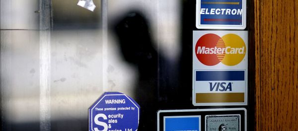 In this July 18, 2012, file photo, a pedestrian walks past credit card logos posted on a downtown storefront in Atlanta. After a stint of frugality, Americans have returned to their borrowing ways. But are they getting into the kinds of debt trouble that lead to recessions? In 2017, U.S. consumers now owe roughly $12.73 trillion to banks and other lenders for mortgages, car loans and credit card spending, according to the New York Federal Reserve. That exceeds even the total before the last financial crisis. In this July 18, 2012, file photo, a pedestrian walks past credit card logos posted on a downtown storefront in Atlanta. After a stint of frugality, Americans have returned to their borrowing ways. But are they getting into the kinds of debt trouble that lead to recessions? In 2017, U.S. consumers now owe roughly $12.73 trillion to banks and other lenders for mortgages, car loans and credit card spending, according to the New York Federal Reserve. That exceeds even the total before the last financial crisis. - Sputnik International