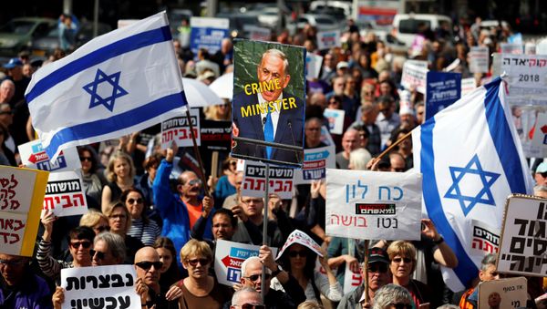 Protesters hold signs calling upon Israeli Prime Minister Benjamin Netanyahu to step down during a rally in Tel Aviv, Israel February 16, 2018 Protesters hold signs calling upon Israeli Prime Minister Benjamin Netanyahu to step down during a rally in Tel Aviv, Israel February 16, 2018 - Sputnik International