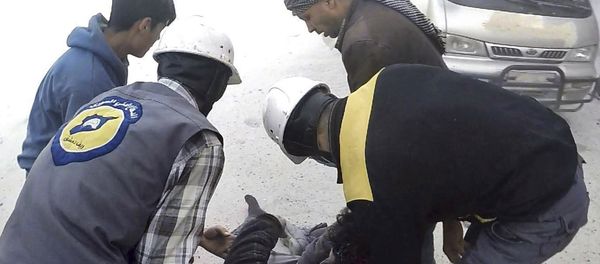 This photo provided by the Syrian Civil Defense White Helmets, which has been authenticated based on its contents and other AP reporting, shows members of the Syrian Civil Defense group helping a wounded man after airstrikes hit Ghouta, a suburb of Damascus, Syria, Thursday, March. 1, 2018 - Sputnik International
