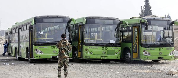 A picture taken on March 13, 2018 shows buses waiting to evacuate civilians on the government side of the Wafideen checkpoint on the outskirts of the Syrian capital Damascus neighbouring the Eastern Ghouta enclave - Sputnik International