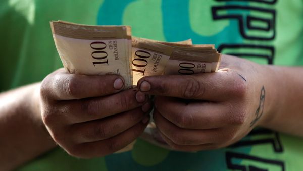 A cashier counts Venezuelan bolivar notes at a street market in downtown Caracas, Venezuela - Sputnik International