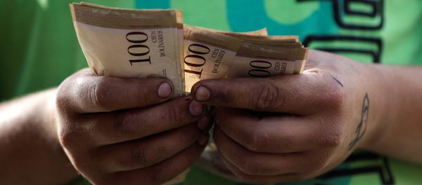 A cashier counts Venezuelan bolivar notes at a street market in downtown Caracas, Venezuela A cashier counts Venezuelan bolivar notes at a street market in downtown Caracas, Venezuela - Sputnik International