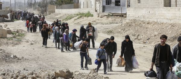 Syrians civilians evacuated from the Eastern Ghouta enclave pass with belongings through the regime-controlled corridor opened by government forces in Hawsh al-Ashaari, east of the enclave town of Hamouria on the outskirts of the capital Damascus on March 15, 2018 Syrians civilians evacuated from the Eastern Ghouta enclave pass with belongings through the regime-controlled corridor opened by government forces in Hawsh al-Ashaari, east of the enclave town of Hamouria on the outskirts of the capital Damascus on March 15, 2018 - Sputnik International