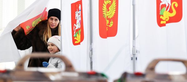 A woman with a child during the voting at the Russian presidential elections at polling station No. 13-06 in Moscow A woman with a child during the voting at the Russian presidential elections at polling station No. 13-06 in Moscow - Sputnik International