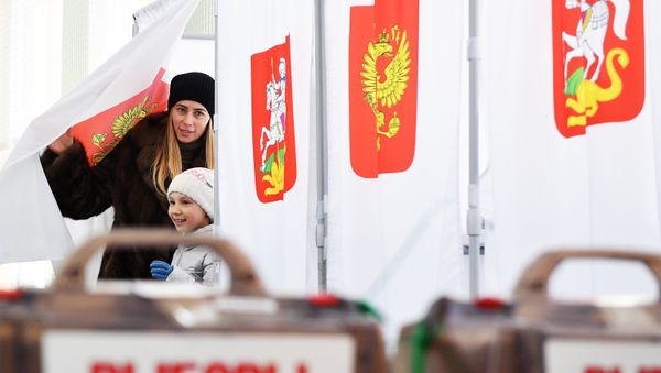 A woman with a child during the voting at the Russian presidential elections at polling station No. 13-06 in Moscow - Sputnik International