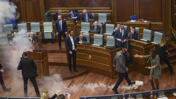 Kosovo policemen (R and L) prepare to remove a tear gas canister throwed by Kosovo's opposition lawmakers, in Pristina's parliament assembly room on March 21, 2018 before a vote on a key boarder deal with Montenegro Kosovo policemen (R and L) prepare to remove a tear gas canister throwed by Kosovo's opposition lawmakers, in Pristina's parliament assembly room on March 21, 2018 before a vote on a key boarder deal with Montenegro - Sputnik International