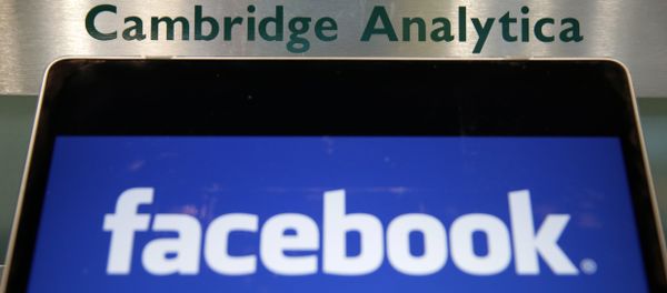A laptop showing the Facebook logo is held alongside a Cambridge Analytica sign at the entrance to the building housing the offices of Cambridge Analytica, in central London A laptop showing the Facebook logo is held alongside a Cambridge Analytica sign at the entrance to the building housing the offices of Cambridge Analytica, in central London - Sputnik International