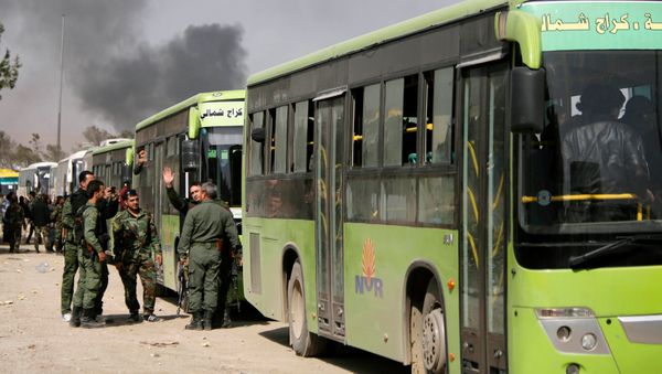 Members of Syrian forces of President Bashar al Assad stand next to buses carrying rebels and their families before they are evacuated, at Harasta highway outside Jobar, in Damascus, Syria March 25, 2018 - Sputnik International