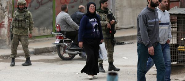 People walk as Turkish soldiers stand guard in the center of Afrin, Syria People walk as Turkish soldiers stand guard in the center of Afrin, Syria - Sputnik International