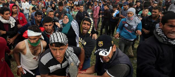 A wounded Palestinian woman is evacuated during clashes with Israeli troops, during a tent city protest along the Israel border with Gaza, demanding the right to return to their homeland, the southern Gaza Strip A wounded Palestinian woman is evacuated during clashes with Israeli troops, during a tent city protest along the Israel border with Gaza, demanding the right to return to their homeland, the southern Gaza Strip - Sputnik International