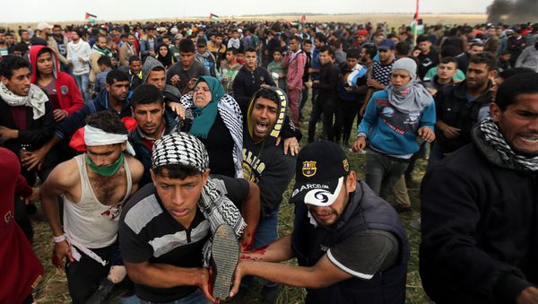 A wounded Palestinian woman is evacuated during clashes with Israeli troops, during a tent city protest along the Israel border with Gaza, demanding the right to return to their homeland, the southern Gaza Strip A wounded Palestinian woman is evacuated during clashes with Israeli troops, during a tent city protest along the Israel border with Gaza, demanding the right to return to their homeland, the southern Gaza Strip - Sputnik International