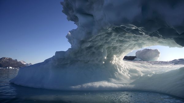 The sun sets through a hole melted in an iceberg floating in the Nuup Kangerlua Fjord near Nuuk in southwestern Greenland, Tuesday Aug. 1, 2017. - Sputnik International