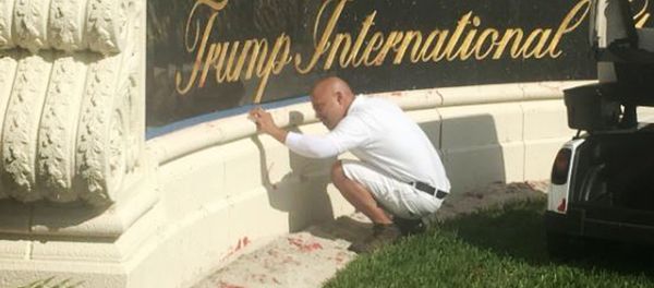 A worker cleans up red paint from the stone sign at the entrance to the Trump International Golf Club in West Palm Beach, Fla., Sunday, April 1, 2018. A worker cleans up red paint from the stone sign at the entrance to the Trump International Golf Club in West Palm Beach, Fla., Sunday, April 1, 2018. - Sputnik International