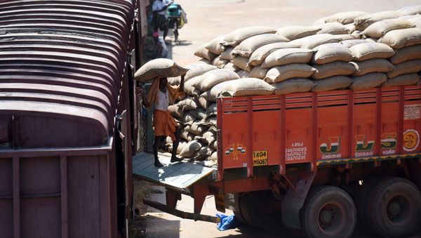 An Indian labourer loads grain sakcs on to a truck at a railway goods yard in Chennai on August 3, 2016 - Sputnik International