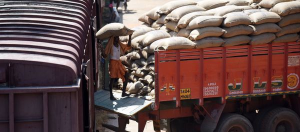 An Indian labourer loads grain sakcs on to a truck at a railway goods yard in Chennai on August 3, 2016 - Sputnik International
