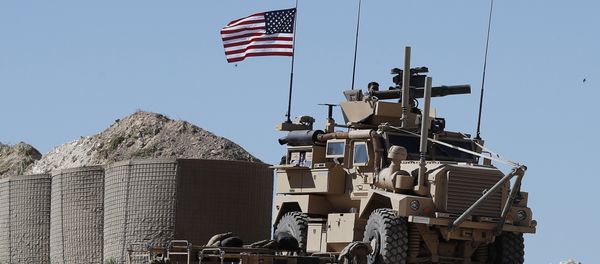 A U.S. soldier sits on an armored vehicle on a newly installed position, near the tense front line between the U.S-backed Syrian Manbij Military Council and the Turkish-backed fighters, in Manbij, north Syria, Wednesday, April 4, 2018 - Sputnik International