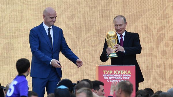 (File) Russian President Vladimir Putin kick starts the FIFA World Cup Trophy Tour at the Grand Sports Arena, which was opened after a reconstruction, during the visit to the Luzhniki Olympic Complex in Moscow. Left: FIFA President Gianni Infantino - Sputnik International