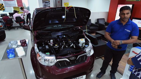 This photo taken on July 21, 2017 shows a sales executive talking about Mahindra's electric car e2o Plus on display at a showroom in New Delhi - Sputnik International