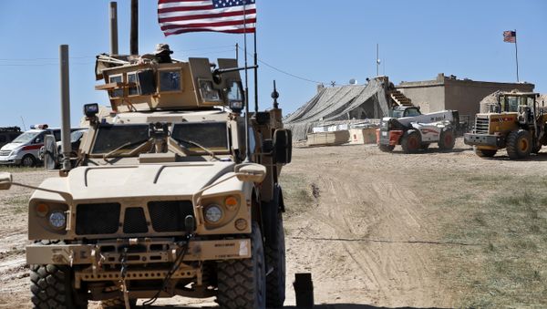 A U.S. soldier, left, sits on an armored vehicle behind a sand barrier at a newly installed position near the tense front line between the U.S-backed Syrian Manbij Military Council and the Turkish-backed fighters, in Manbij, north Syria, Wednesday, April 4, 2018 A U.S. soldier, left, sits on an armored vehicle behind a sand barrier at a newly installed position near the tense front line between the U.S-backed Syrian Manbij Military Council and the Turkish-backed fighters, in Manbij, north Syria, Wednesday, April 4, 2018 - Sputnik International