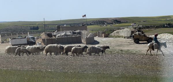 A Syrian shepherd herds his flock, as he passes in front of a newly installed U.S. position near the tense front line between the U.S-backed Syrian Manbij Military Council and the Turkish-backed fighters, in Manbij, north Syria, Wednesday, April 4, 2018 - Sputnik International