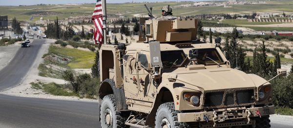 A U.S. soldier sits on an armored vehicle on a road leading to the tense front line with Turkish-backed fighters, in Manbij, north Syria, Wednesday, April 4, 2018 A U.S. soldier sits on an armored vehicle on a road leading to the tense front line with Turkish-backed fighters, in Manbij, north Syria, Wednesday, April 4, 2018 - Sputnik International