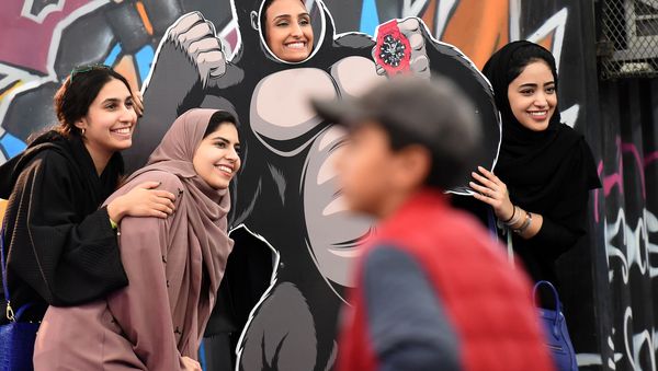 Saudi girls pose for a group picture as one stands behind a frame depicting King Kong, while attending the first ever Comic-Con Arabia event held in the capital Riyadh on November 25, 2017 Saudi girls pose for a group picture as one stands behind a frame depicting King Kong, while attending the first ever Comic-Con Arabia event held in the capital Riyadh on November 25, 2017 - Sputnik International